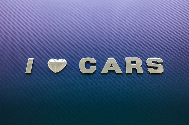 Photo concept of love of cars, driving. letters on carbon fiber surface