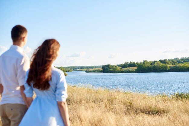 The concept of love, good relationships, understanding and harmony. Lovely young couple is walking in nature holding hands.