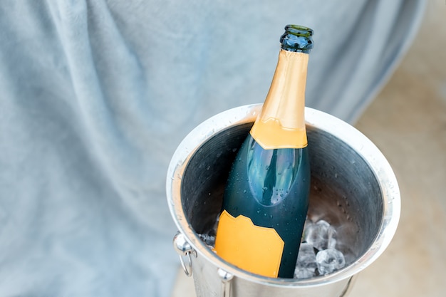 Concept of luxury life with champagne bottle in ice bucket. Celebration theme with champagne still life.