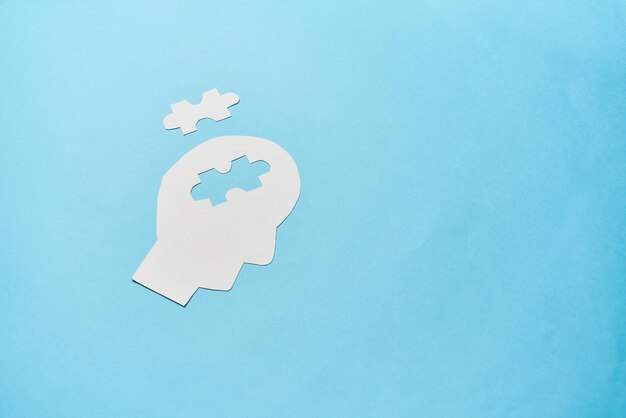 Concept of memory loss and dementia disease and alzheimer Head silhouette with jigsaw puzzle