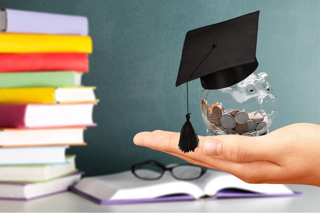 Foto concetto di denaro per l'istruzione, barattolo di vetro con monete e cappello di laurea