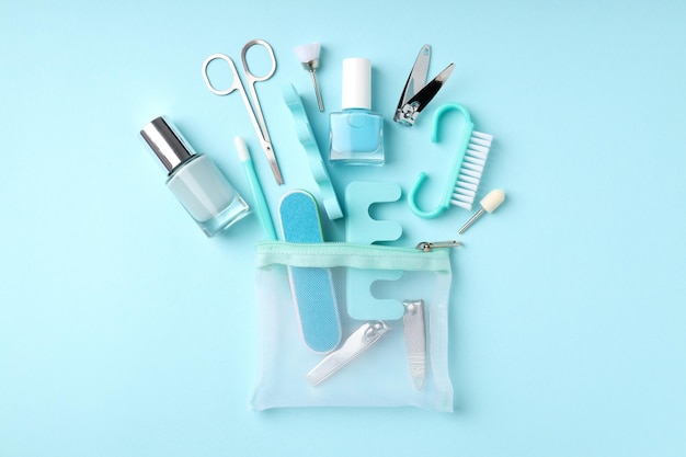 Concept of nail care with manicure accessories on blue background