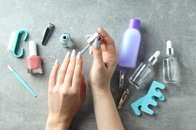 concept of nail care with manicure accessories on gray textured background