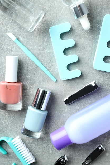 Concept of nail care with manicure accessories on gray textured background