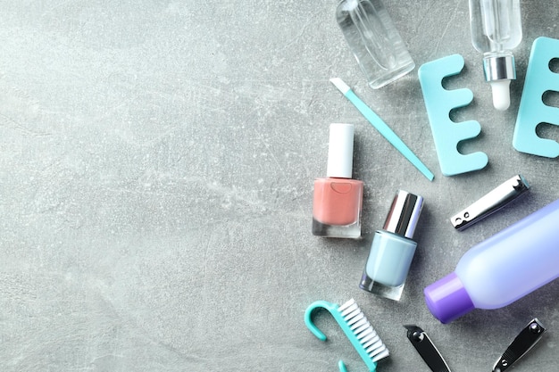 Concept of nail care with manicure accessories on gray textured background