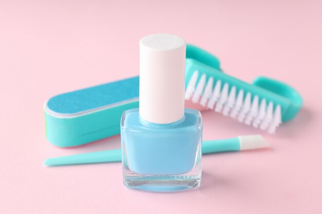 Concept of nail care with manicure accessories on pink background