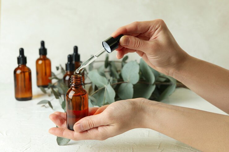 Photo concept of natural cosmetics with female hand dripping eucalyptus oil