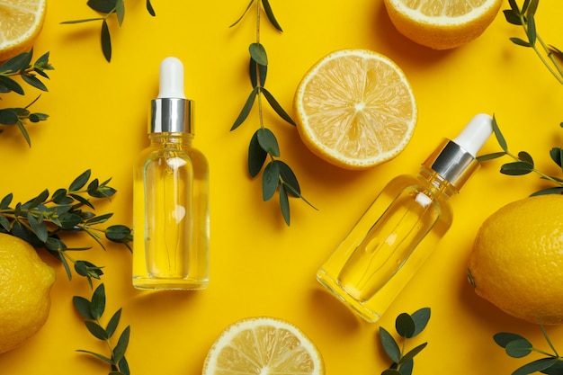 黄色の背景にレモンオイルと自然化粧品の概念