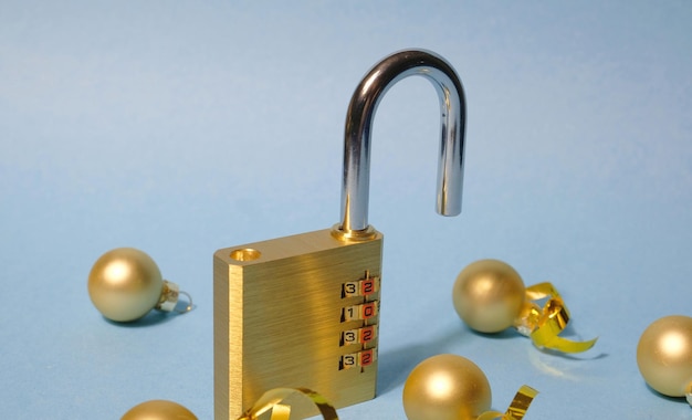 Photo concept new year brass yellow combination open lock on a light blue background christmas balls