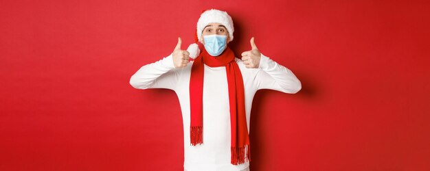 Concept of new year coronavirus and holidays cheerful man celebrating new year and social distancing...