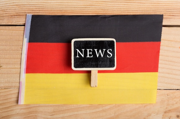 コンセプトニュースフィード-最新ニュース、ドイツの国の旗、黒板、木製の背景のテキストニュース
