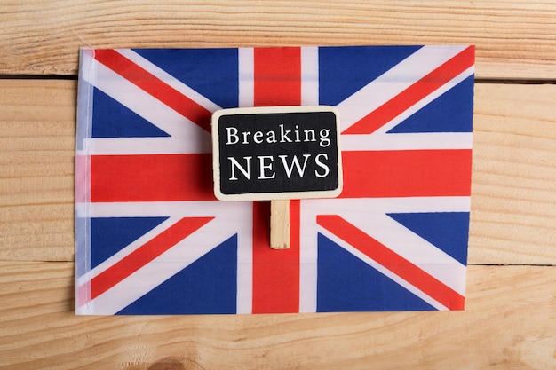 concept news feeds - Breaking news, Great Britain country's flag, blackboard and the text Breaking News on wooden background