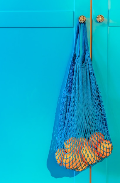 Photo concept no plastic. oranges in a blue mesh bag. free plastic