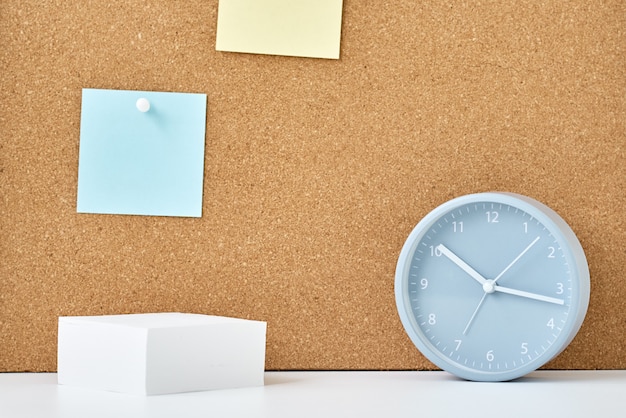 Concept of notes, goals, memo or action plan. Sticky notes on a cork board and alarm clock  in workplace office or home