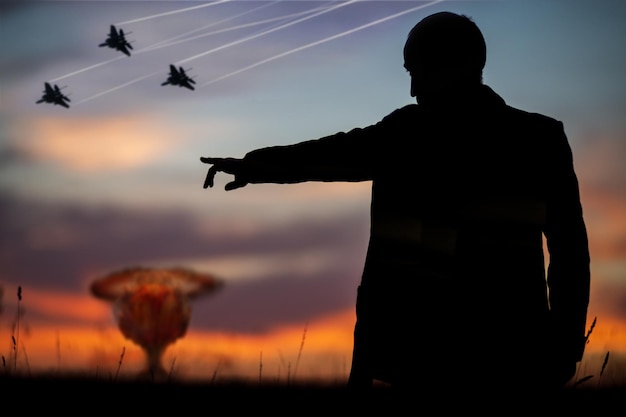 The concept of a nuclear strike Silhouette of fighters and a man who points forward with his hand to attack A politician who started a nuclear war