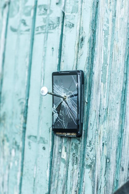 Concept of obsolete technologymobile phone nailed to the fence a large nail