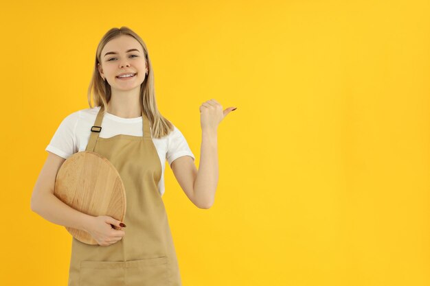 黄色の背景に職業若い女性ウェイターの概念