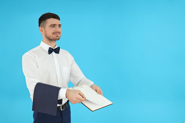 Concept of occupation young waiter on blue background