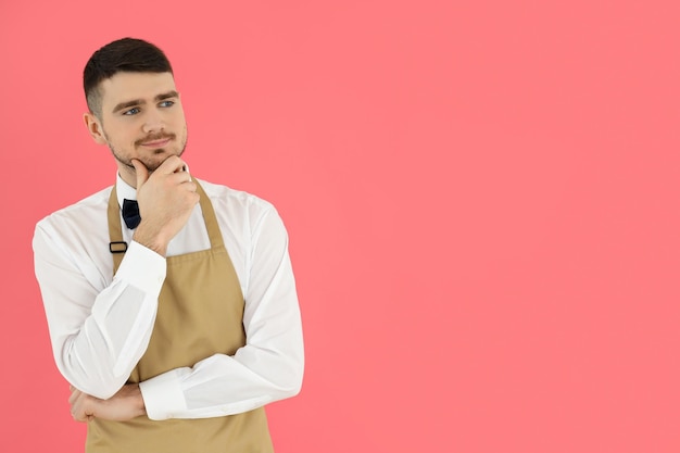 Concept of occupation young waiter on pink background