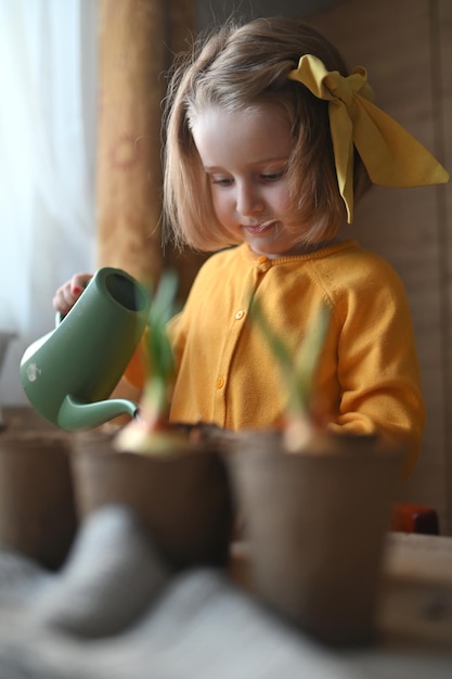 写真 ガーデニングのコンセプト少女は、作物を育てるポットに土を注ぐ苗の種を植えることに従事しています