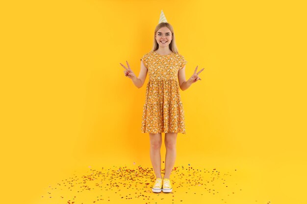 黄色の背景に若い女性とお誕生日おめでとうの概念