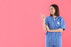 Концепция профессии молодой женщины-врача на розовом фоне