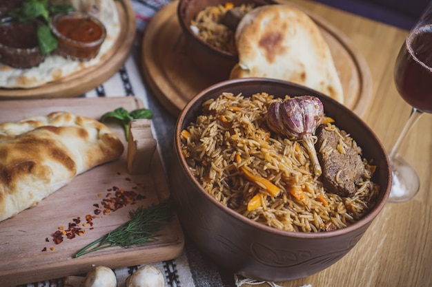 The concept of oriental cuisine. Homemade georgian Uzbek pilaf or plov from lamb served in cast iron cookware