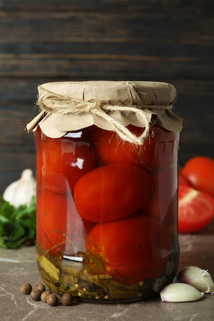 Concept of pickled vegetables with tomatoes on gray textured table