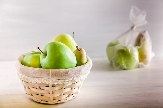 Concept plastic free fruit in a plastic bag and wicker basket on white background