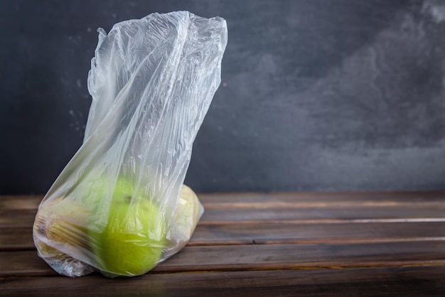 Concept plastic gratis fruit in een plastic zak op bruine achtergrond met kopieerruimte