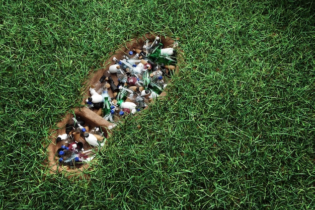 Concept plasticvervuiling menselijke voetafdruk in groen gras gevuld met plastic afval