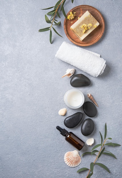 Concept plat lag beauty spa met natuurlijke cosmetische producten peeling natuurlijke zeep, massagestenen en olie op blauwe achtergrond. Bovenaanzicht en ruimteafbeelding kopiëren