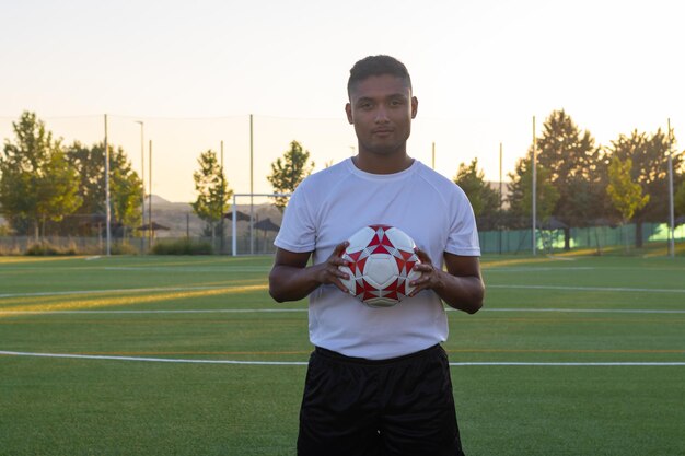 Foto il concetto di giocare a calciocalciatore latino con calcio sul campo di calcio