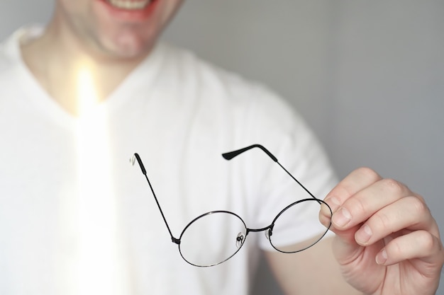 視力低下の概念。コンタクトレンズとメガネを手に持ってください。メガネやレンズの宣伝用ポスター。