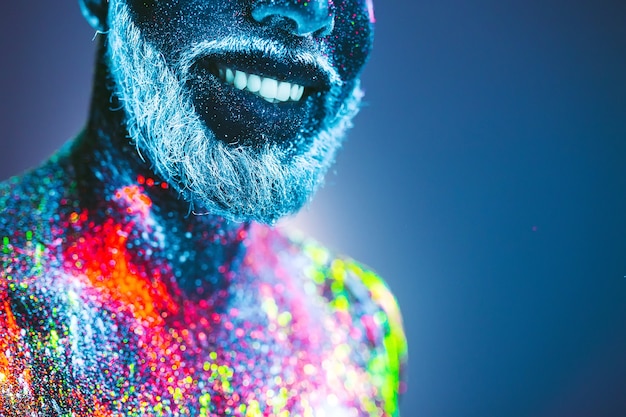 写真 概念。ひげを生やした男の肖像。男は紫外線の粉で塗られています。