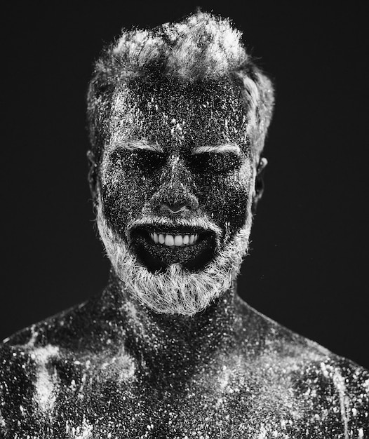 Concept. Portret van een bebaarde man. De man is geschilderd in ultraviolet poeder.