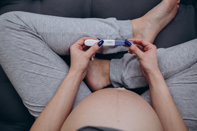 임신 테스트기를 들고 임신에 대해 처음 알게 된 방법을 기억하는 임산부의 개념