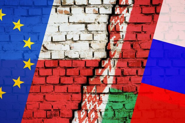 Concetto di problema sul confine polonia-bielorussia. bandiera della polonia e dell'ue da un lato e bandiera della bielorussia e della russia dall'altro lato della crepa sul muro di mattoni