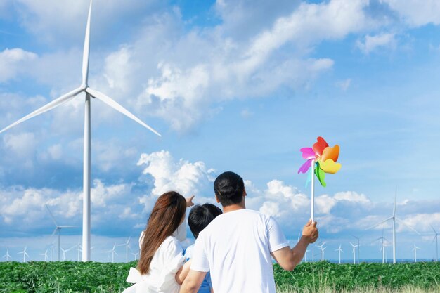 Concept of progressive happy family enjoying their time at the wind turbine farm