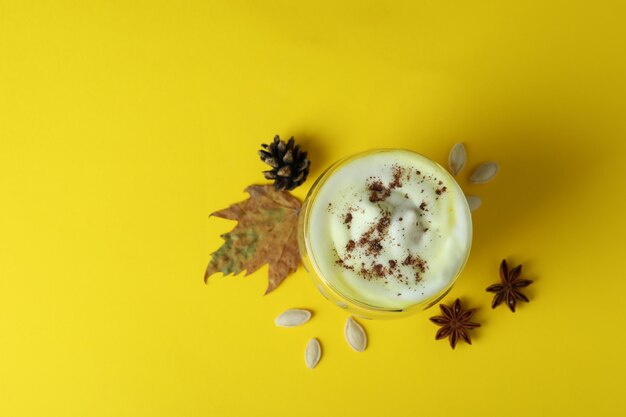 Concept of pumpkin latte on yellow background