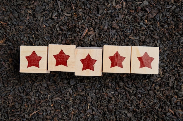 The concept of the quality of tea rating. Stars on wooden cubes.