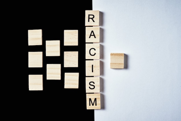 Понятие расизма и недопонимания между людьми, предрассудков и дискриминации. Многие деревянные блоки отделены от одного слова расизм