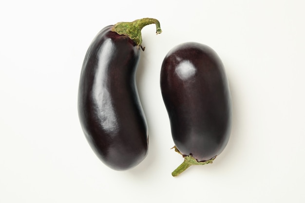 Concept of raw vegetables with eggplants on white