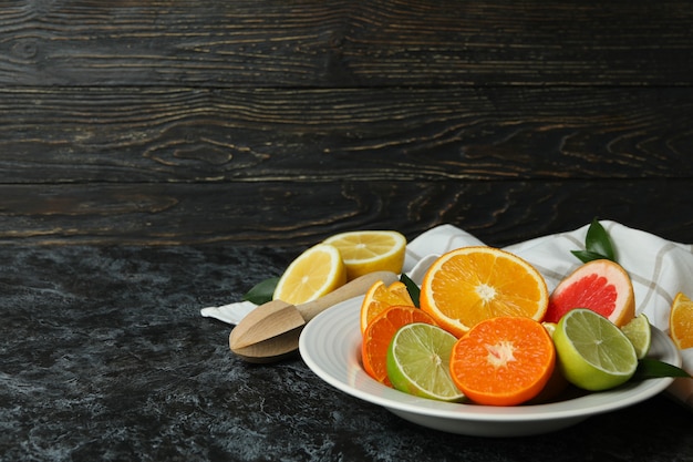 黒のスモーキーテーブルに異なる柑橘類と熟した食品の概念