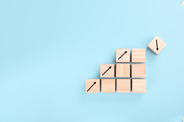 Photo the concept of risk in business. growth on stacked wooden cubes on blue background.