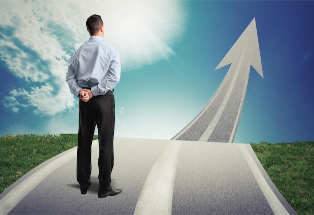 Concept of the road to success with a businessman standing on the road photo by