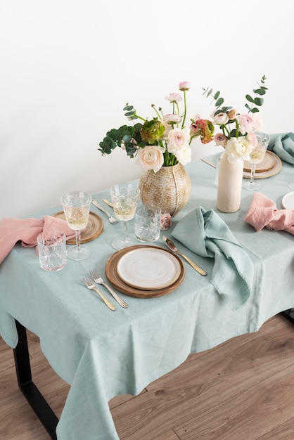 Concept of romanitic Easter table with flowers and light green tablecloth selective focus image