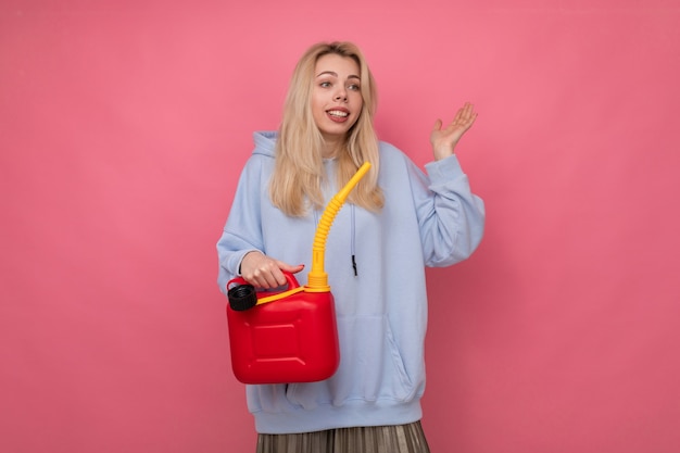 The concept of running out of gas on a trip with woman holding a gas canister