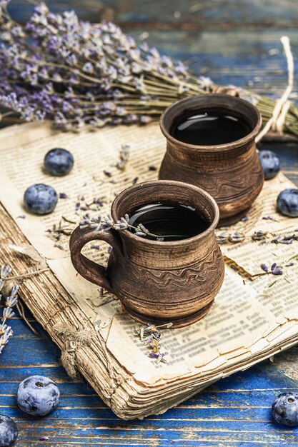 素朴なスタイルのお茶のコンセプト ラベンダーの花とブルーベリー ヴィンテージブック