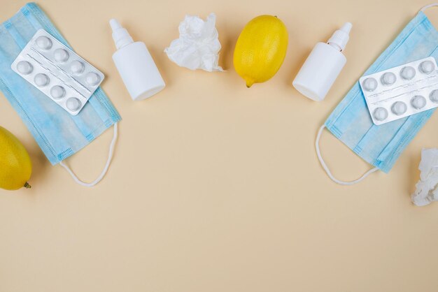 Il concetto di malattie stagionali vista dall'alto foto di medicina spray e sciroppo bottiglia pillole capsule termometro tovaglioli limone su sfondo beige isolato naso che cola e freddo